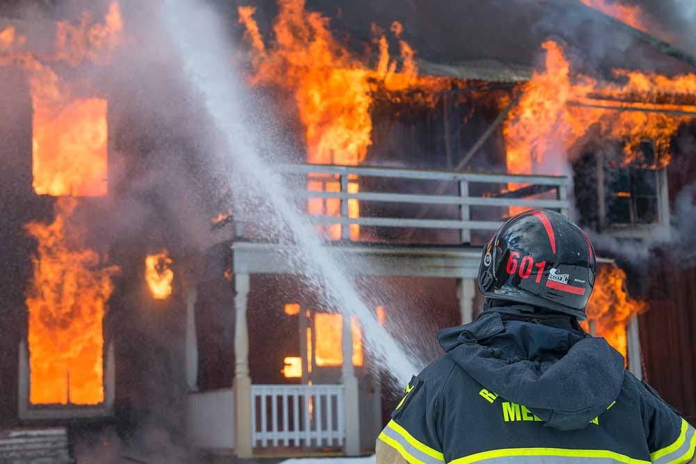 a firefighter putting out a house fire