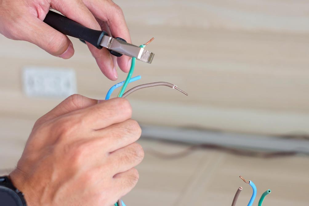 cutting electrical wires to repair a wall socket